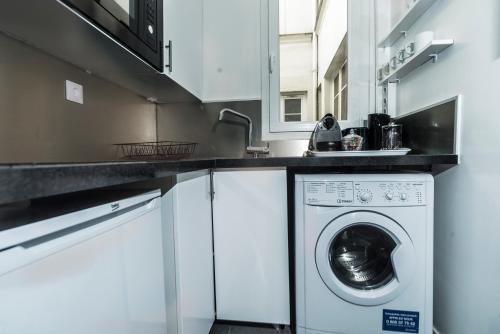une cuisine avec une machine à laver sous un comptoir dans l'établissement Saint Michel Quartier Latin With AC, à Paris