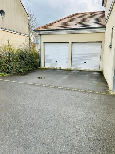 two garage doors on the side of a house at Cozy in Bussy-Saint-Georges