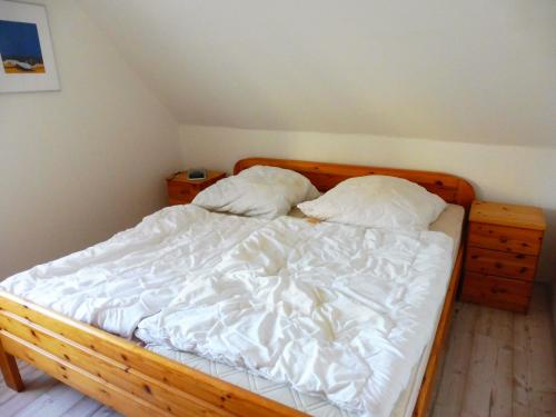 a bedroom with a wooden bed with two pillows at Apartments Bensersiel in Esens