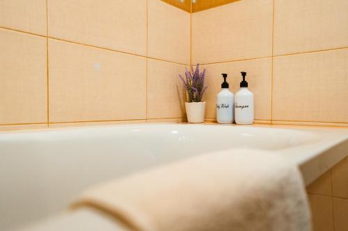 a bathroom with a tub with two bottles of wine at Maria's Premium Suite in Baia Mare