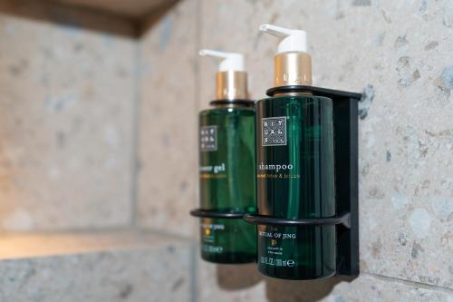 two green bottles are attached to a wall at Cocoon Theresienwiese in Munich