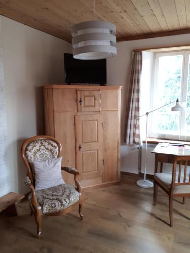 a room with a chair and a table and a lamp at Huus74 in Menziken