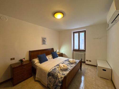 une chambre avec un grand lit avec des oreillers bleus dans l'établissement Castagna Apartment, à Bellagio