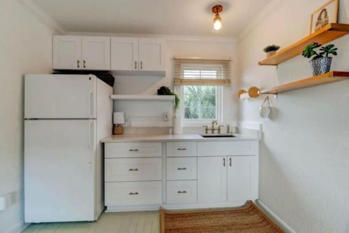 a kitchen with white cabinets and a white refrigerator at Melrose of Flagler Beach in Flagler Beach