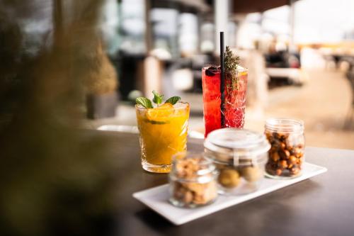 a table topped with three cocktails on a tray at COMO Alpina Dolomites in Alpe di Siusi