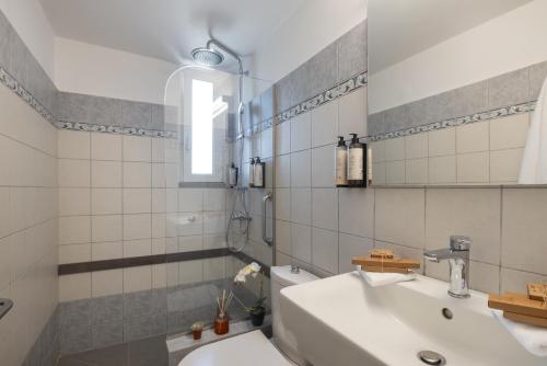 a white bathroom with a sink and a toilet at Unique apartment in Corfu Town