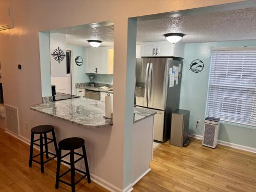 a kitchen with a counter and two bar stools at Ocean Lakes Golf Cart Pet Friendly 1648 in Myrtle Beach