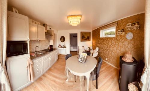 a kitchen with a table and a dining room at Au refuge du spéléo in Hotton
