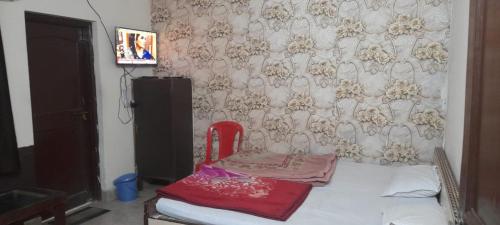 Zimmer mit einem Bett mit einem roten Stuhl. in der Unterkunft Hotel Raj Palace in Rewa