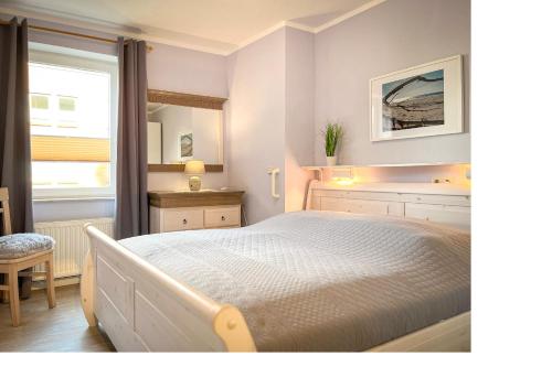 a bedroom with a large bed and a window at Goosbrink Wohnung 13 in Boltenhagen