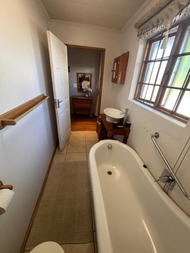 a bathroom with a bath tub and a sink at 33 On Loop, Flat 4 in Ladybrand