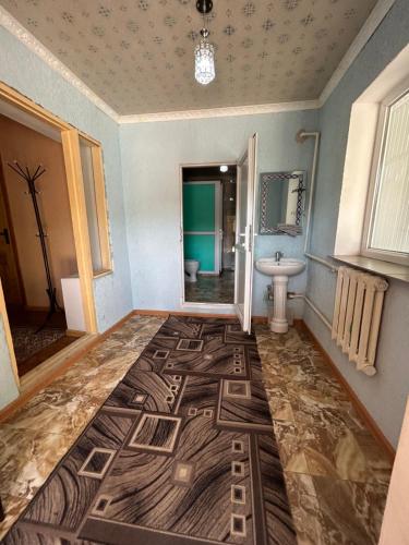 a bathroom with a large rug on the floor at Green Forest guest house in Ivano-Alekseyevka