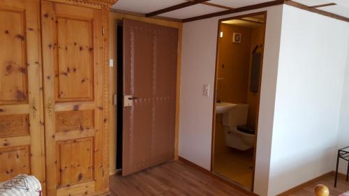 a bathroom with a door and a toilet in a room at Gästehaus Krone in Schönengrund