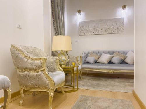 una sala de estar con un sofá y una silla en 2BR Downtown Alia Khan, Fully equipped Gem, en El Cairo