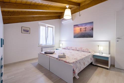 Un dormitorio blanco con una cama y una ventana. en Colibrì Apartament, en Lanciano
