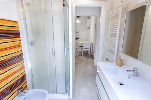 Un baño blanco con ducha y lavabo. en Colibrì Apartament, en Lanciano