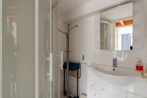une salle de bain blanche avec un lavabo et un miroir dans l'établissement Pilier6 near beach parking outdoor, à Pornic