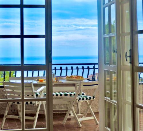 a room with a table and a view of the ocean at Un posto al Sole, Bordighera in Bordighera