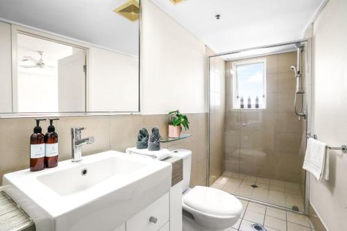 a bathroom with a sink and a toilet and a shower at Cairns Central Apartment 1011 in Cairns