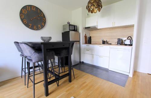 une cuisine avec une table et une horloge au mur dans l'établissement Victoria1 - Nice apartment 4ppl near Disneyland, à Serris