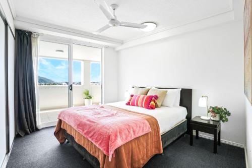 a bedroom with a bed and a large window at Cairns Central Apartment 1011 in Cairns