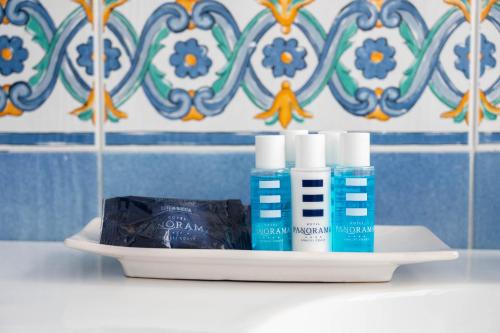 a shelf with three bottles ofodorizers and a box ofnesia at Hotel Panorama in Maiori