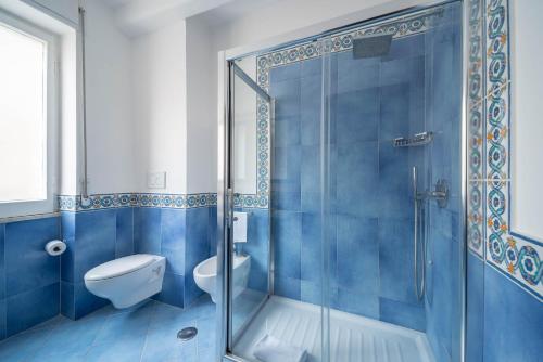 a blue bathroom with a toilet and a shower at Hotel Panorama in Maiori