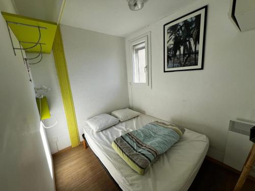 Cette petite chambre comprend un petit lit. dans l'établissement Studio 5/6 Personnes avec Piscine et WIFI - FR-1-784-40, à Gruissan