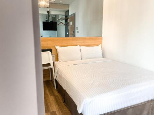 a small bedroom with a bed and a desk at CHECK inn Express Taichung FuXing Hall 2 in Taichung