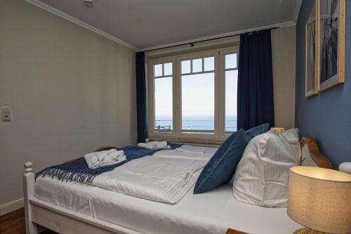 ein Schlafzimmer mit einem großen Bett mit Fenster in der Unterkunft Ferienwohnung mit traumhaftem Meerblick - Haus am Meer FeWo 03 in Lohme