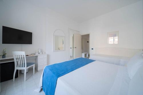a white bedroom with a large bed and a desk at Hotel Panorama in Maiori