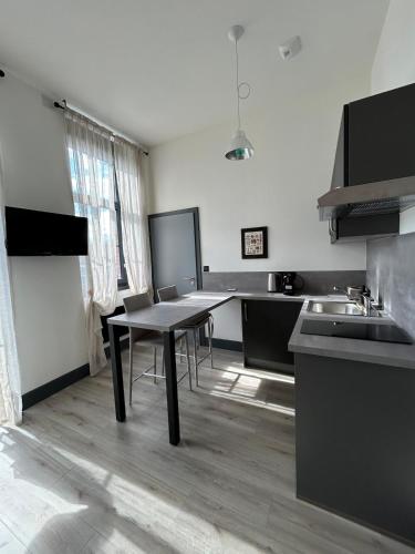 a kitchen with a table and a sink in it at Studio Sylvinite in Wittelsheim