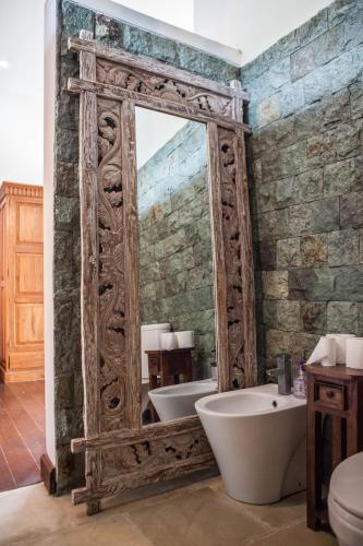 a bathroom with a large mirror and a tub at Villa More Bali in Uluwatu