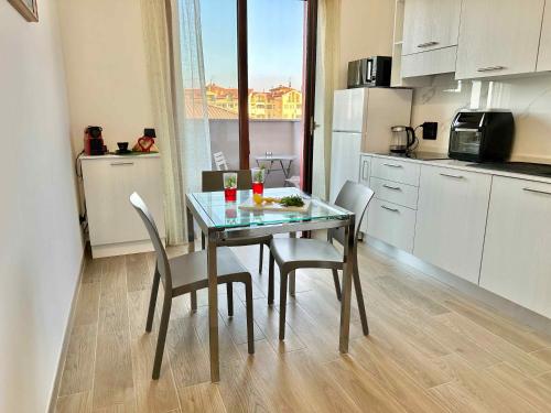a kitchen with a table and chairs and a kitchen with a window at A8 Aloe Fiera Rho -Monza-Como-MXP AMPIO&LUMINOSO MONOLOCALE in Cesate