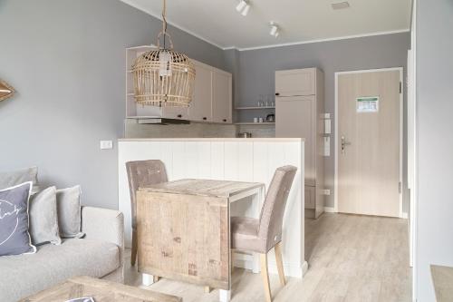 a kitchen and living room with a table and chairs at Beach Apartments Büsum in Büsum