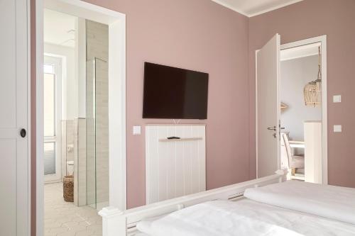 a bedroom with a flat screen tv on a wall at Beach Apartments Büsum in Büsum
