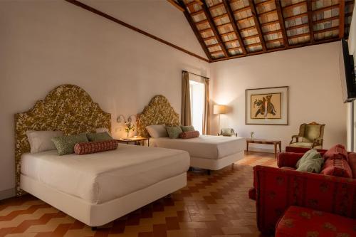 a living room with two beds and a couch at Palacio de los Leones in Lora del Río