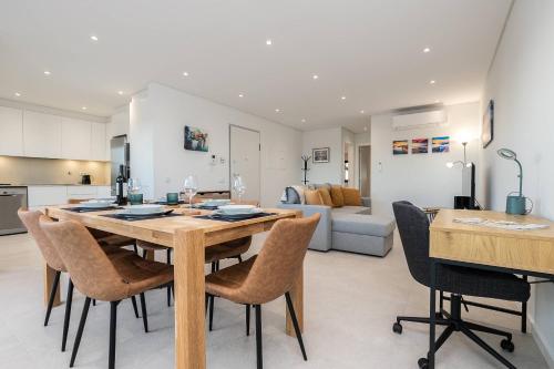 a kitchen and living room with a wooden table and chairs at Sunset View Apartment in Conceicao de Tavira in Tavira