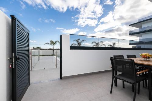 a patio with a table and chairs on a balcony at Sunset View Apartment in Conceicao de Tavira in Tavira