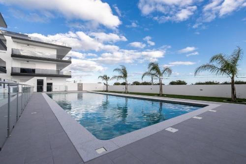 a swimming pool in front of a building at Sunset View Apartment in Conceicao de Tavira in Tavira