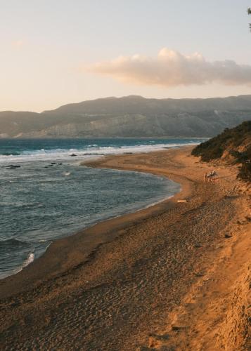 a beach with a group of people walking on it at Villa Anastasia in Apolakkiá