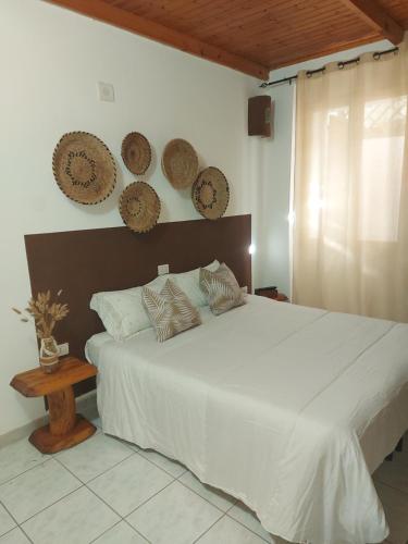 a bedroom with a large white bed with four plates on the wall at Bed and Breakfast Cala Luna in Castelsardo