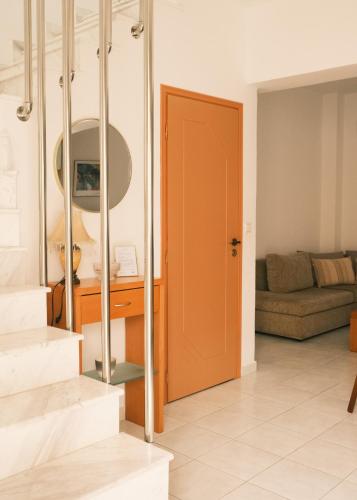 a living room with a orange door and a couch at Villa Anastasia in Apolakkiá
