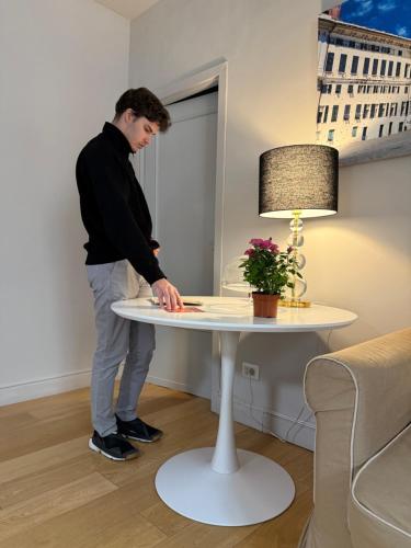 a man standing next to a white table at Palazzo Cambiaso Albergo Etico Genova in Genova