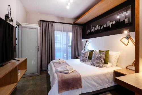 a hotel room with a bed and a television at Akanani Apartments in Pretoria