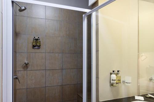 a bathroom with a shower with a glass door at Akanani Apartments in Pretoria