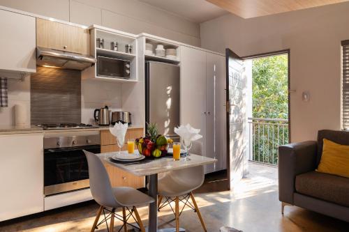 a kitchen and living room with a table and chairs at Akanani Apartments in Pretoria