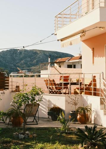 a white building with potted plants in front of it at Villa Anastasia in Apolakkiá