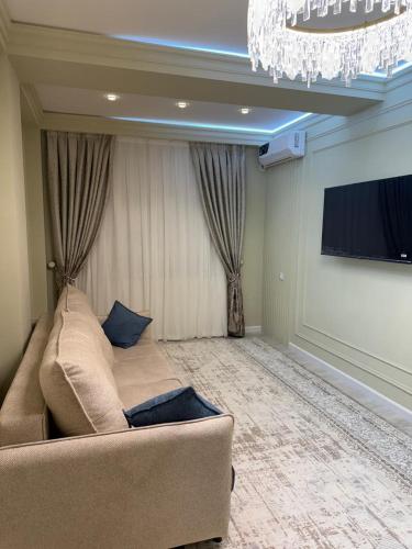 a living room with a couch and a flat screen tv at Yunusabad Xonsaroy PARLAMENT in Tashkent