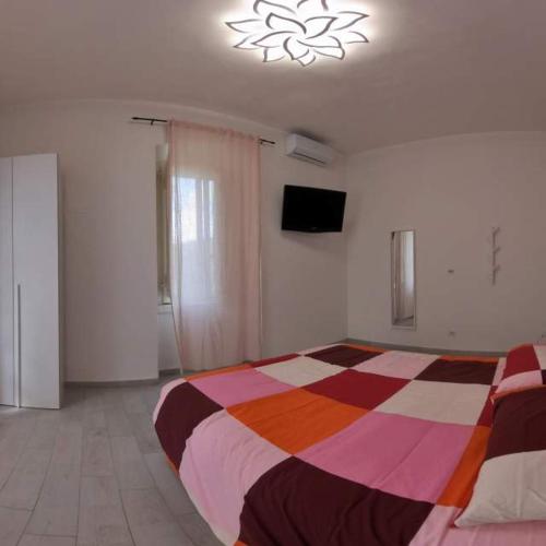 a bedroom with a colorful bed and a television at La Stazione Sabina Alloggio Turistico in Stimigliano